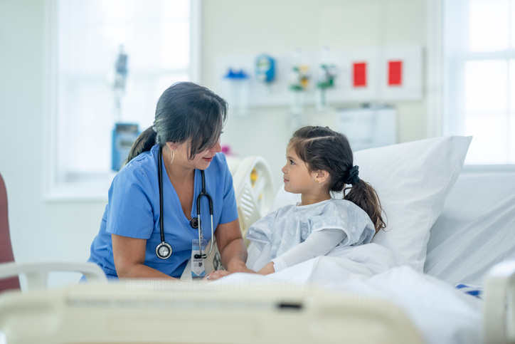 nurse by the hospital bedside of a girl.