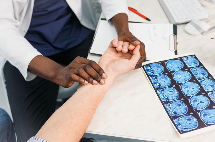 doctor places fingers on a patient's wrist to check heart rate.