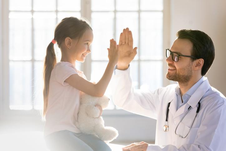 Doctor and girl share a high five.