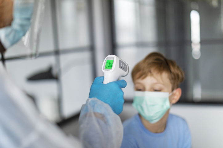 checking the temperature of a boy's forehead.