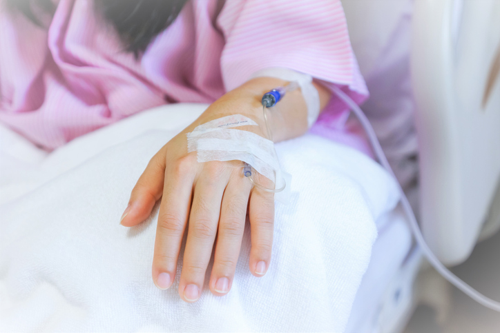 close up of the upper part girl's hand with IV inserted,