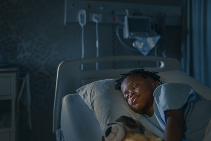 boy sleeping at night in a hospital room.