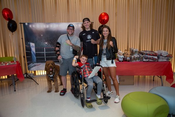 UFC athletes with male patient in wheelchair