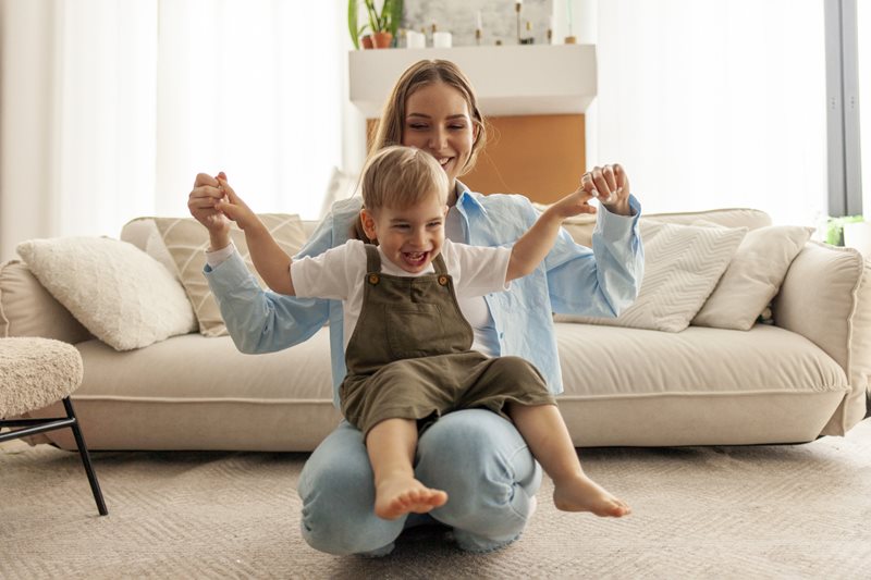 Mom playing with son in living room