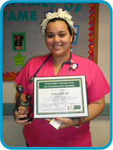 awardee wearing a headband of daisies, daisy award statue, and certificate.