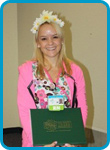 awardee wearing a headband of daisies, daisy award statue, and certificate.