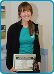 awardee wearing a headband of daisies, daisy award statue, and certificate.