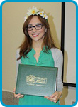 awardee wearing a headband of daisies, daisy award statue, and certificate.