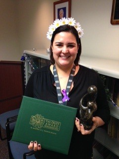 awardee wearing a headband of daisies, daisy award statue, and certificate.