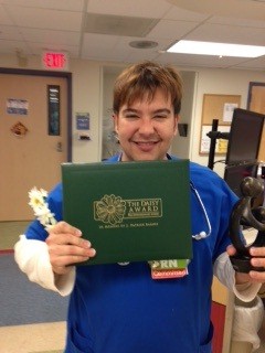 awardee wearing a headband of daisies, daisy award statue, and certificate.