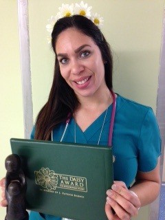 awardee wearing a headband of daisies, daisy award statue, and certificate.