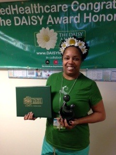awardee wearing a headband of daisies, daisy award statue, and certificate.