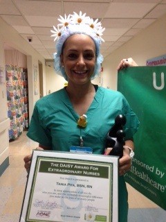 awardee wearing a headband of daisies, daisy award statue, and certificate.