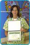 awardee wearing a headband of daisies, daisy award statue, and certificate.