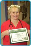 awardee wearing a headband of daisies, daisy award statue, and certificate.