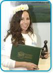 awardee wearing a headband of daisies, daisy award statue, and certificate.