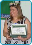 awardee wearing a headband of daisies, daisy award statue, and certificate.