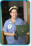 awardee wearing a headband of daisies, daisy award statue, and certificate.