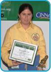 awardee wearing a headband of daisies, daisy award statue, and certificate.