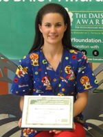 awardee wearing a headband of daisies, daisy award statue, and certificate.