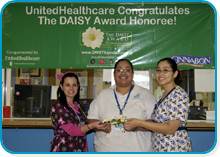 awardee wearing a headband of daisies, daisy award statue, and certificate.